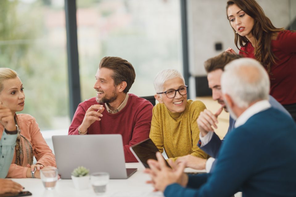 A group of colleagues mid-discussion around a meeting table